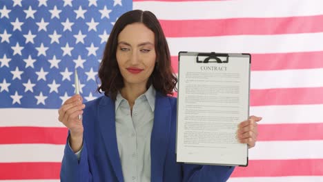 woman holding contract and pen in front of american flag