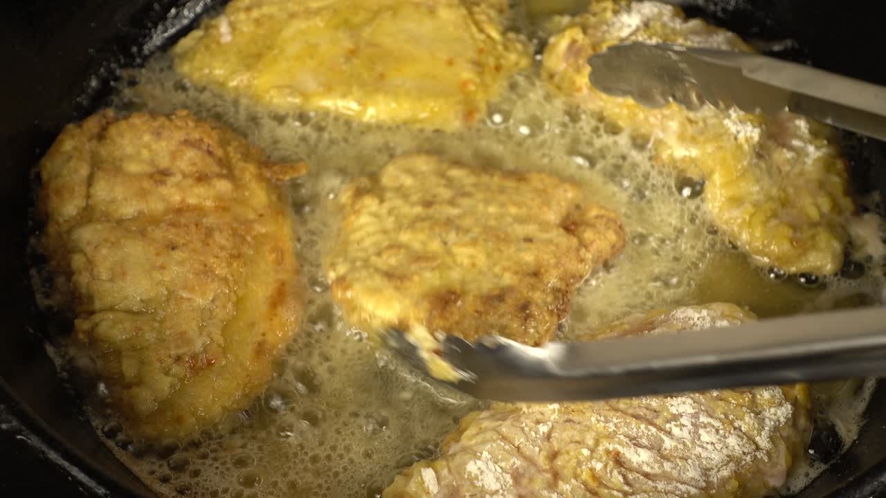 Preparation of a chicken chop on a cast-iron pan. Cooking process