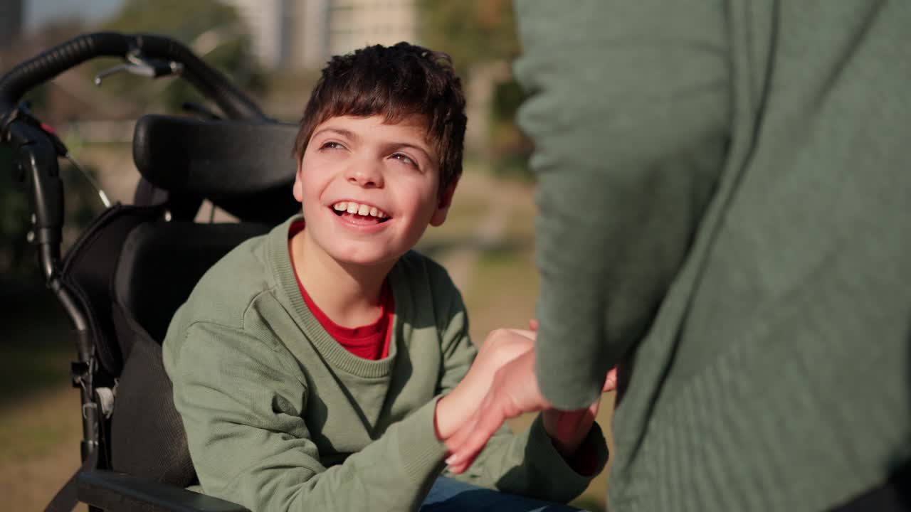 Happy disabled child in wheelchair with caregiver
