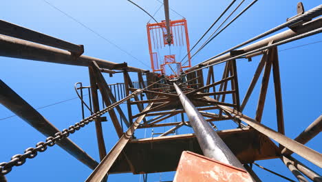 high metal tower with used at the site for drilling mineral natural resources. low angle view on the support for oil production.