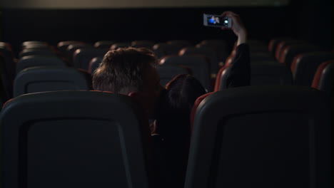 jóvenes besándose en una sala de cine vacía
