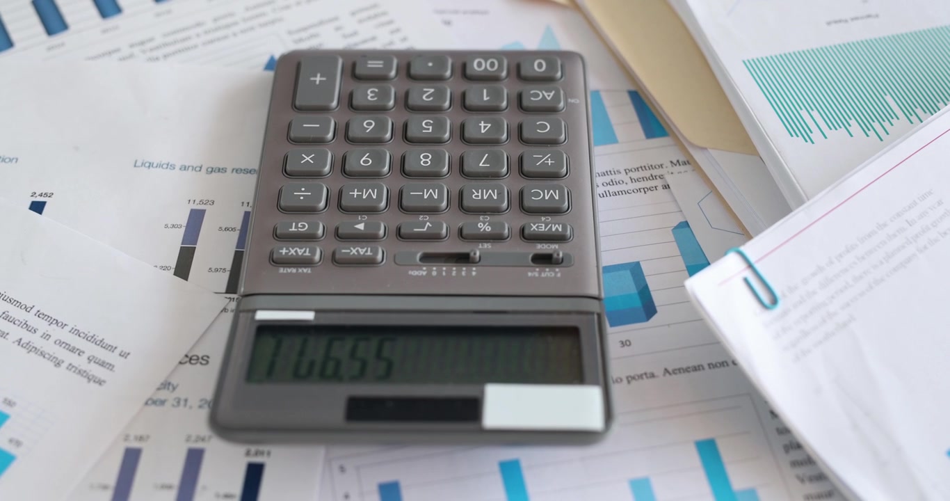 Calcolatrice appoggiata su documenti con grafici in ufficio, filmato 4k al rallentatore