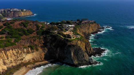disparo de drones volando hacia una enorme mansión en un acantilado en laguna beach california