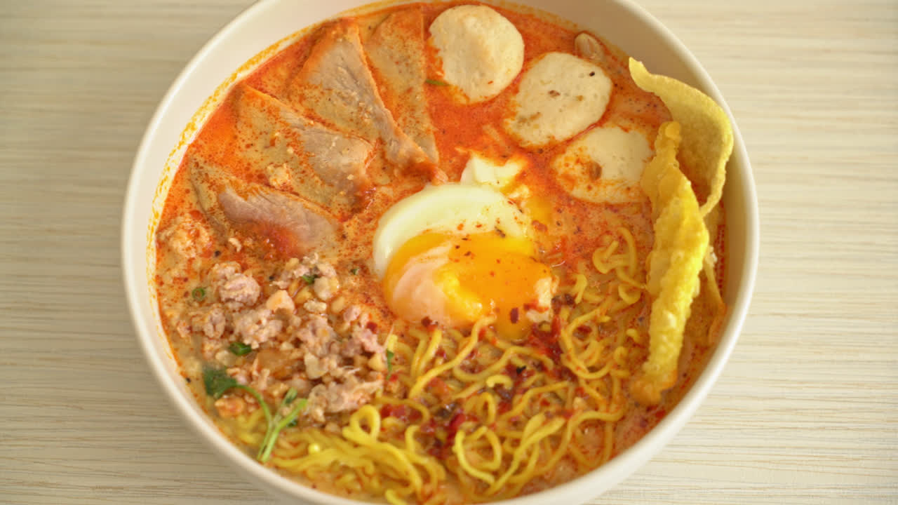 fideos de huevo con carne de cerdo y albóndigas en sopa picante o fideos tom yum al estilo asiático