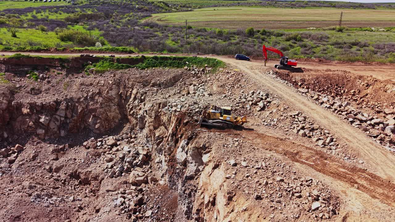 Construction work at a quarry with machinery digging in sunlight