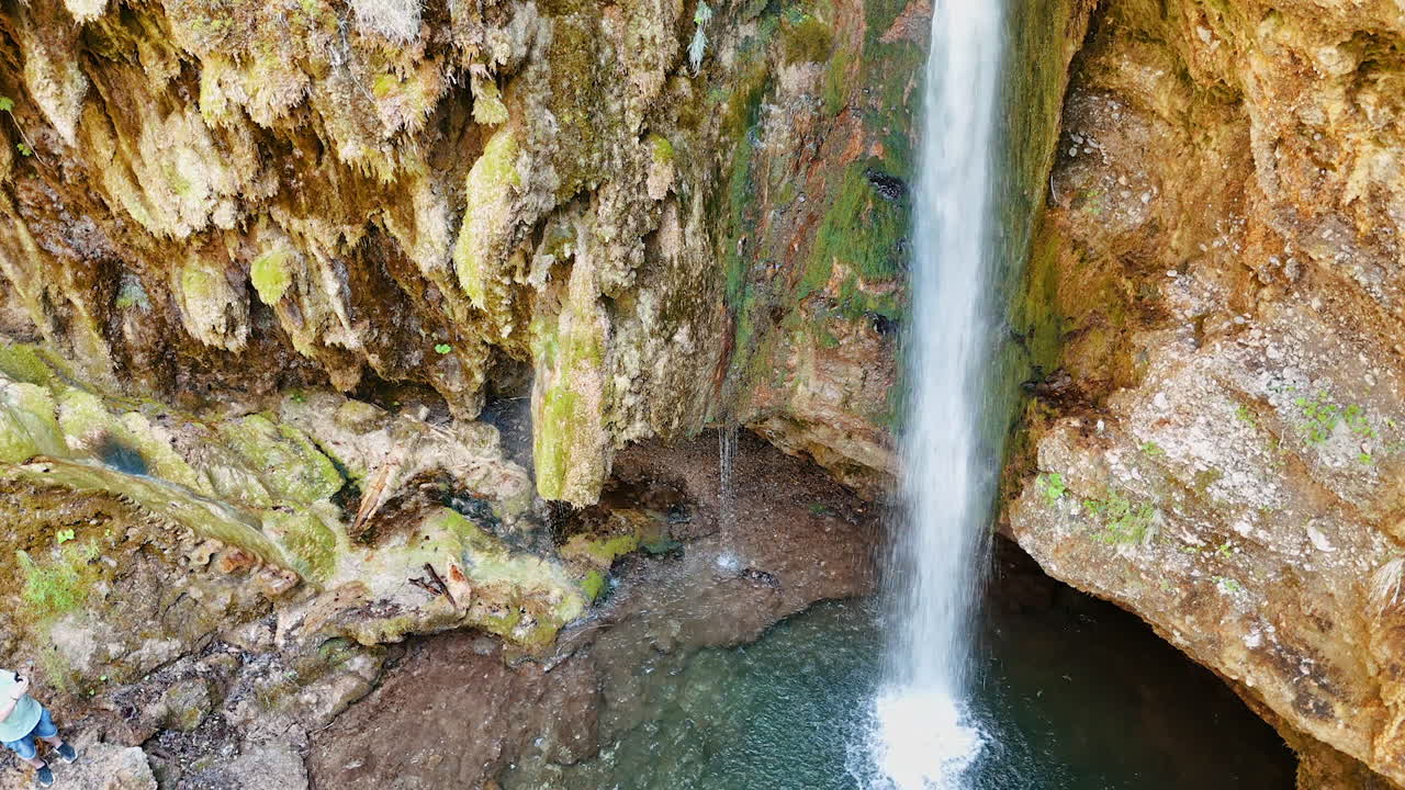 Stunning sandstones covered with mosses and lichens. A little waterfall falls from the rock into the pond.