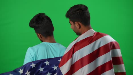 back view two dissatisfied sport fans leaving green screen gesturing talking. young middle eastern friends watching football game at chromakey background walking away. championship loss.