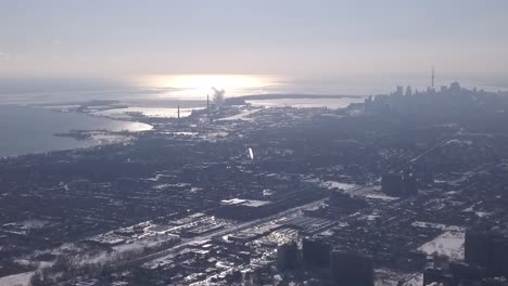 Aerial-Dramatic-Extreme-Long-Shot-of-Toronto-Skyline-during-cold,-snowy,-sunny,-foggy-winter-day-Buildings-and-skyscrapers-Camera-movement:-Camera-Pans-right