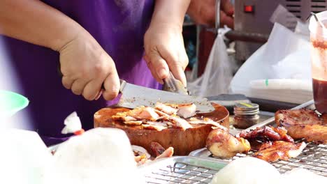 person slicing and serving grilled meat outdoors