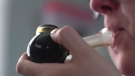 woman with smoke pipe in hand isolated on blurry background - extreme closeup