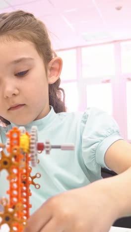 young girl building a mechanical model