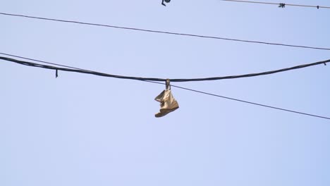 shoes hanging by laces from a wire