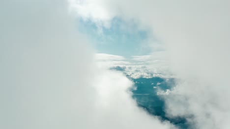 Bird's-eye-view-fast-moving-through-clouds-in-the-sky-discovering-water