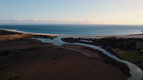 Aerial-view-of-a-river-feeding-into-the-Strait-of-Gibraltar-in-Tarifa,-Spain