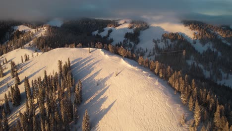 Aerial-View-of-Snow-Capped-Hills-and-Pine-Forest-on-Sunny-Winter-Day,-Tetona-Pass,-Wyoming-USA