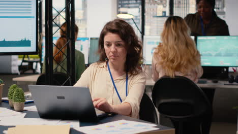 vertical video female general director reviewing data insights on her laptop
