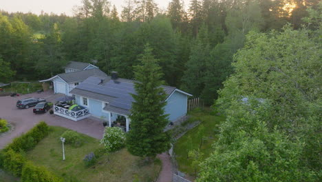 aerial tracking shot in front a house with sunlight collectors on the roof