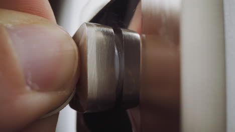la mano del ladrón pone una moneda en la cerradura dividida para abrir la puerta cerrada