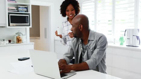 Couple-using-laptop-in-kitchen-4k