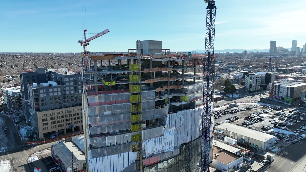 retirada de drones de un edificio de varios pisos en construcción y revelando el horizonte y el paisaje urbano de la ciudad, denver