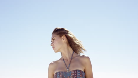 Hermosa-Joven-Atando-El-Cabello-En-Un-Día-Ventoso-En-La-Playa-Tropical-A-Cámara-Lenta