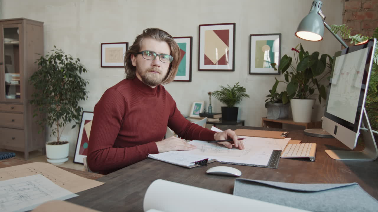 Male Architect With Sketches Posing For Camera