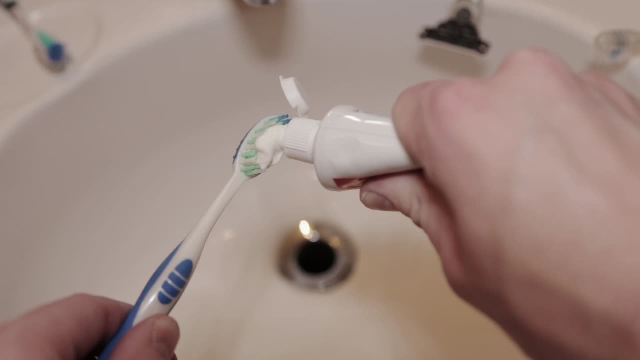Toothpaste is layered onto a toothbrush