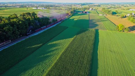 Dampfzug,-Der-An-Einem-Sonnigen-Sommertag-Durch-Amisches-Ackerland-Und-Landschaft-Fährt,-Wie-Von-Der-Drohne-Aus-Gesehen