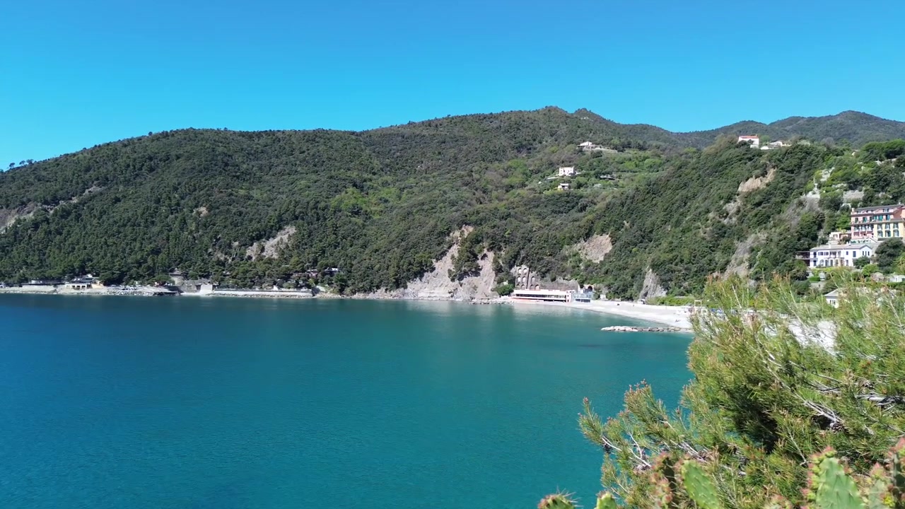 Vista aerea cinematografica di acque cristalline e paesaggi costieri frastagliati nelle Cinque Terre, Italia.
