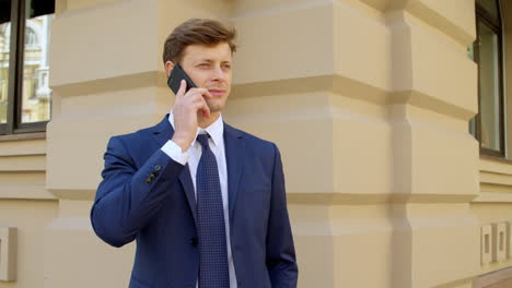 confident business man talking on mobile phone outdoors