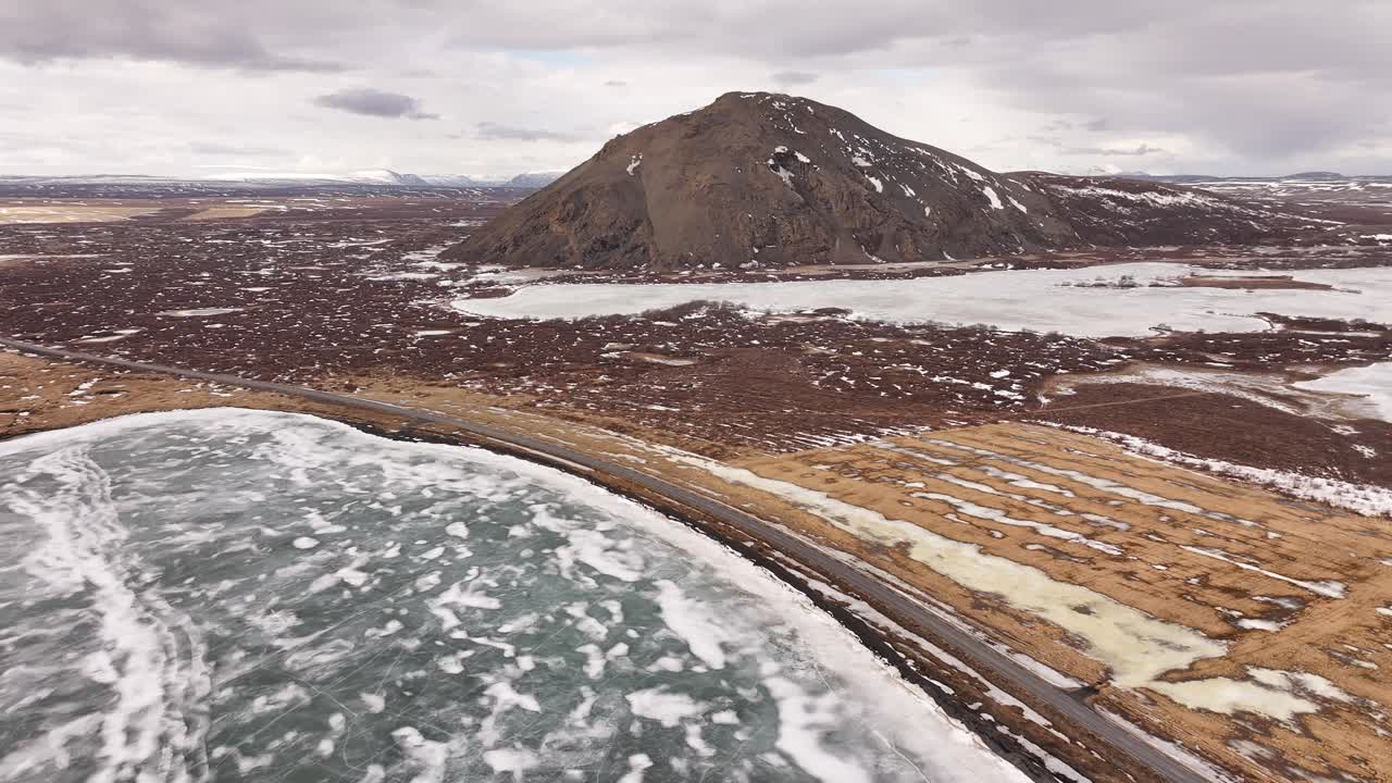 icy lake and volcanic hill near Skútustaðir in the Mývatn region of Iceland