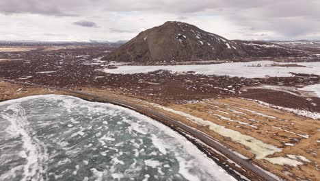 icy lake and volcanic hill near skútustaðir in the mývatn region of iceland