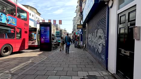 people and buses in a lively street scene