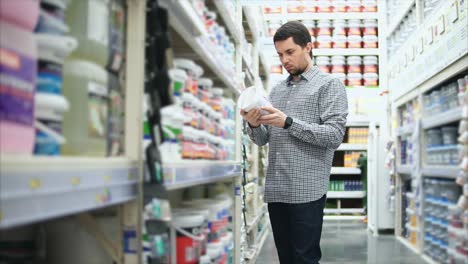 man shopping for paint in a hardware store