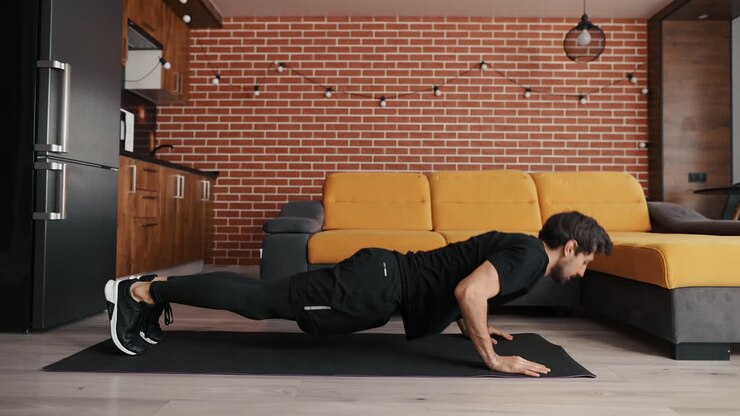 A european man works out, doing push-ups, lying on a mat