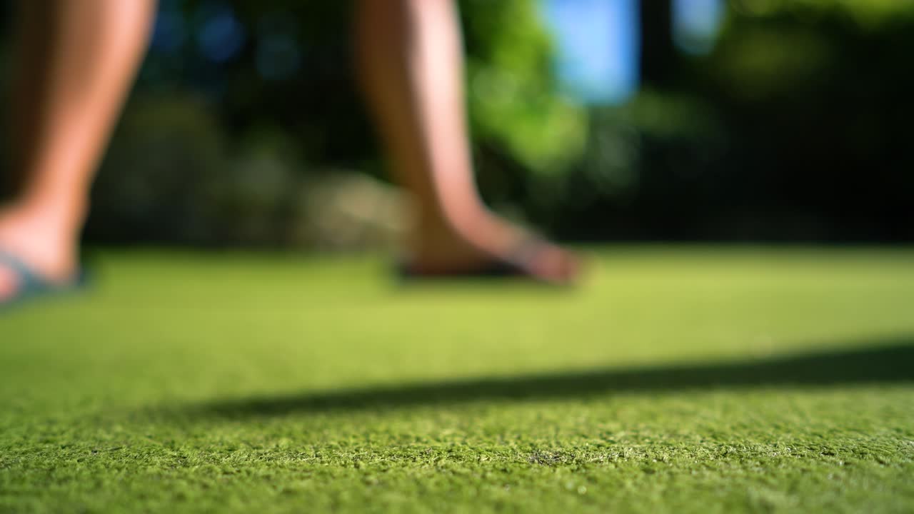 Mini Golf yellow ball with a bat near the hole at sunset