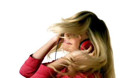 bonita rubia escuchando música sacudiendo la cabeza