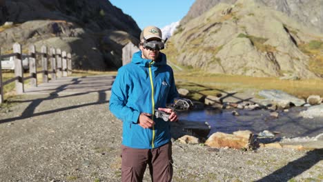 solo operator launching fpv drone wearing goggles on mountain landscape in valmalenco