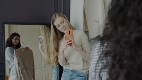 friends trying on clothes and taking selfies
