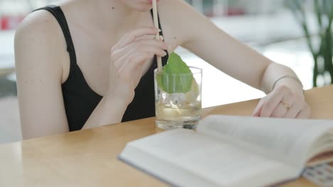 woman enjoying a cocktail and reading a book