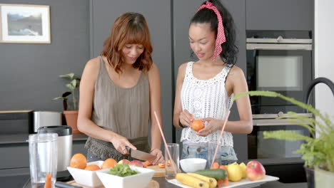 two biracial female friends are preparing food in a modern kitchen