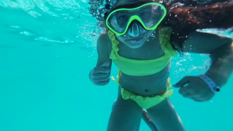 niña con máscara nadando, imágenes subacuáticas de gopro