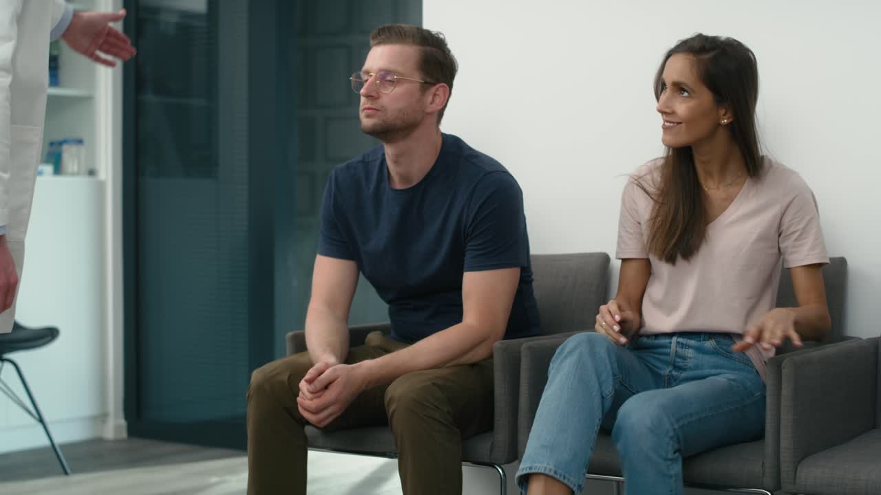 mujer caucásica sentada en la sala de espera y siendo invitada al gabinete