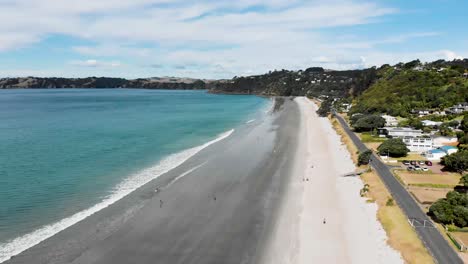 dji mavic air drone flying above a sandy beach on waiheke island in new zealand