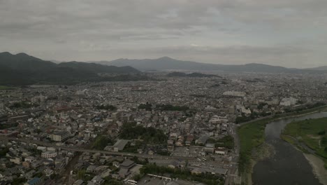 Luftdrohnenaufnahme-Von-Kyoto-Bei-Sonnenuntergang-In-Der-Nähe-Eines-Flusses,-Japan,-Asien