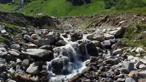 Volando-Bajo-De-Lado-Sobre-Una-Corriente-De-Agua-En-Austria-Con-Muchas-Rocas