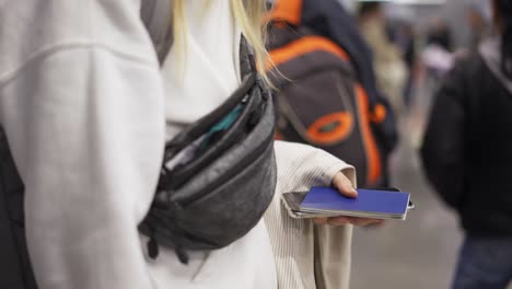 Unrecognizable-female-tourist-holding-documents-while-waiting-for-flight