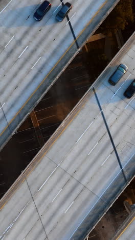 cars go by the multi-lane road on the freeways to both sides. top view on the speedways above water. vertical video