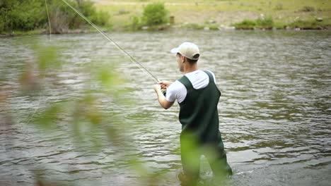 Zeitlupenaufnahme-Eines-Kaukasischen-Männlichen-Fischers,-Der-Seinen-Haken-Beim-Fliegenfischen-Wirft-3