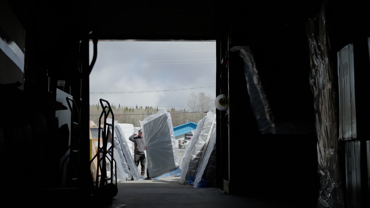 A Group of Employees Load Mattresses Into a Warehouse